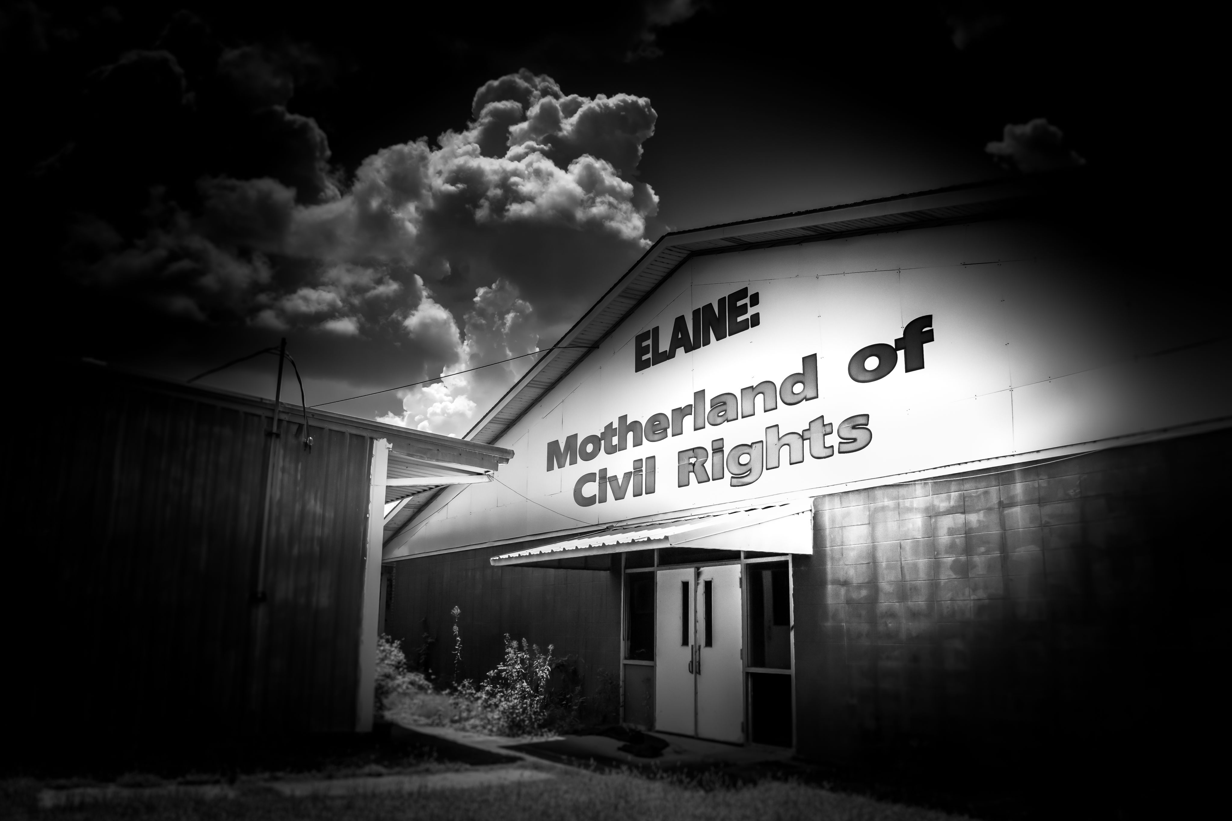 Black and white photo of the side of a building with a sign that says Elaine: Motherland of Civil Rights
