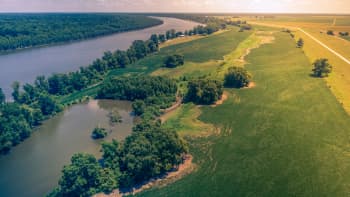 aerial shot of the Mississippi River and farmland, with a levee and overflow